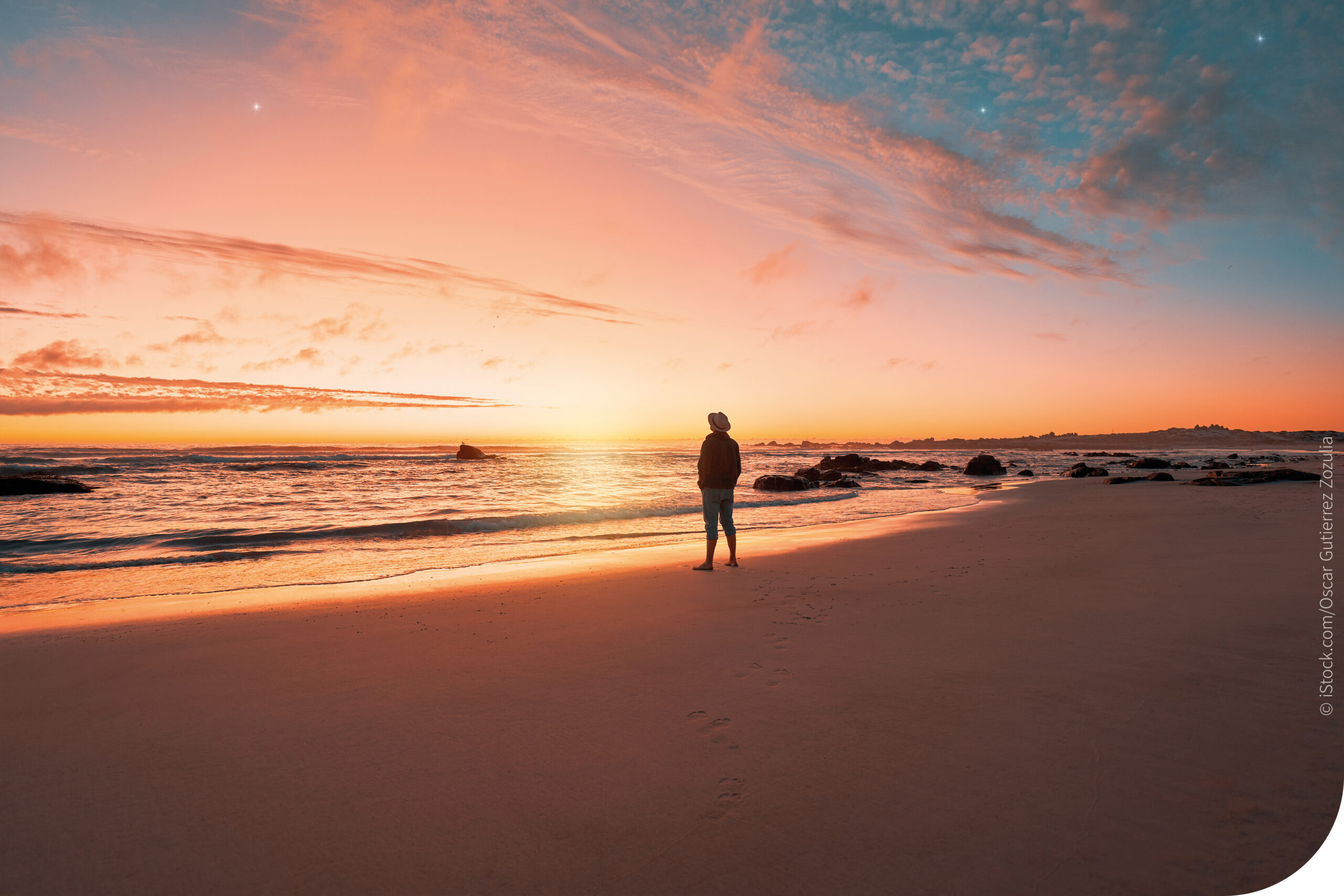 Ein Mann steht am Meer im Sonnenuntergang