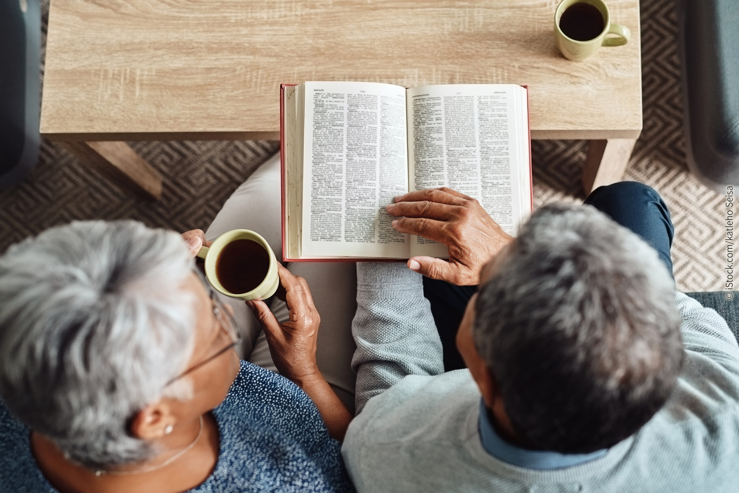 Ein altes Ehepaar liest in der Bibel zum Thema: Liebt mich Gott